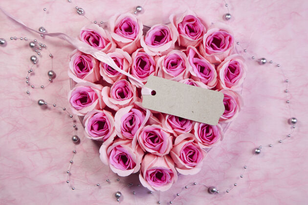 礼物高角度拍摄一个美丽的心形粉红玫瑰束标签礼物安排标签