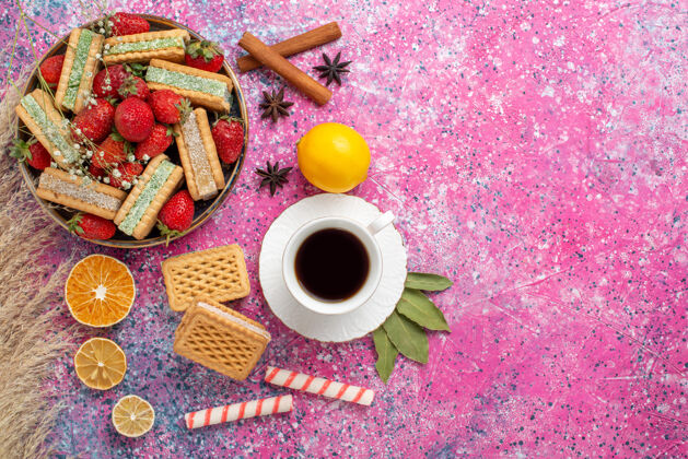 华夫饼美味的华夫饼干的顶视图 粉色表面有新鲜的红色草莓咖啡生的饼干