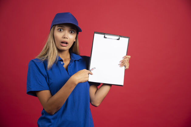 女士穿着蓝色制服的年轻女子用铅笔指着剪贴板女人剪贴板模型