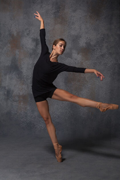 跳跃年轻漂亮的现代风格舞者在灰色背景上摆姿势模特芭蕾舞演员敏捷