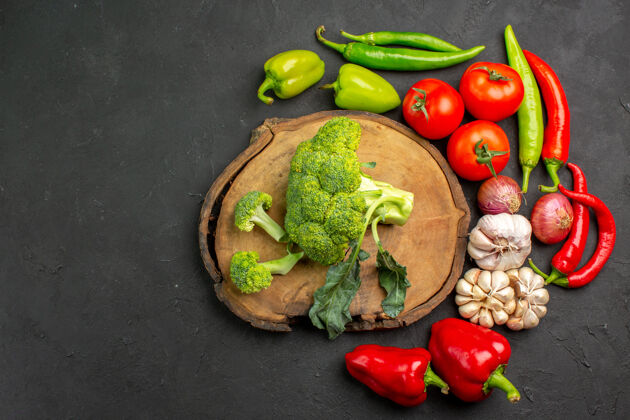 素食顶视图新鲜的绿色西兰花和新鲜蔬菜放在深色的桌子上沙拉成熟健康西兰花沙拉深色