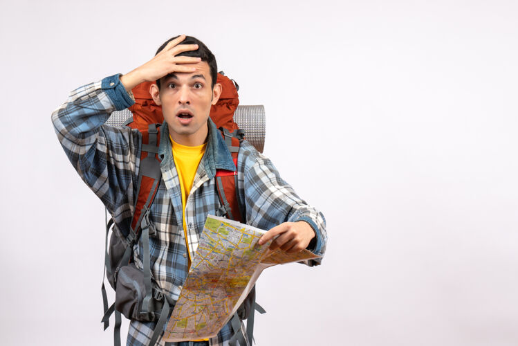 地图正面图惊讶的年轻旅行者背着背包拿着地图漂亮头发猎人