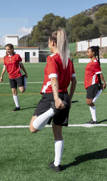 全速在足球场上伸展腿的女人们足球运动成人