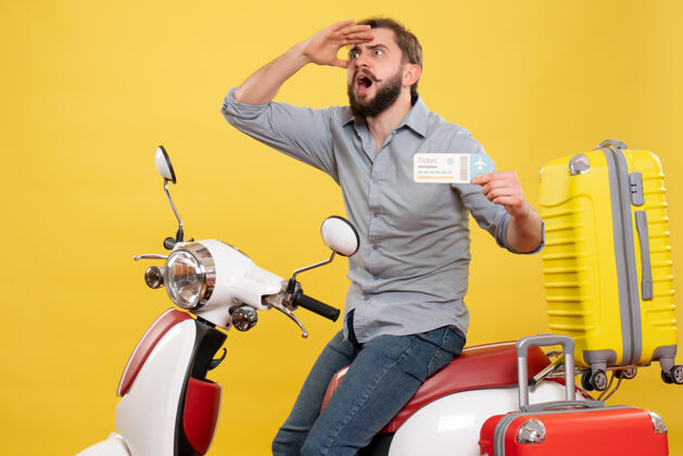 情绪旅游概念与年轻的情绪集中胡须男子坐在摩托车上 并持有黄色的车票成人微笑摩托车