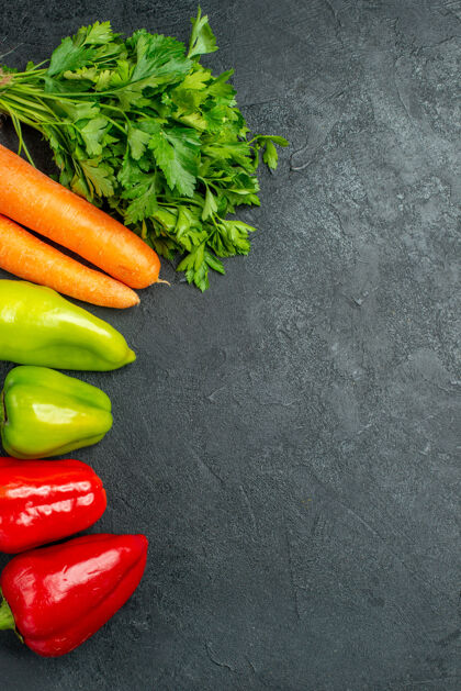 沙拉深灰色桌子左侧胡萝卜 青菜和甜椒的俯视图健康饮食蔬菜