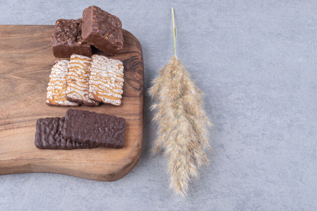 威化饼干羽毛草杆旁边的一块板饼干和华夫饼上的大理石外套羽毛巧克力