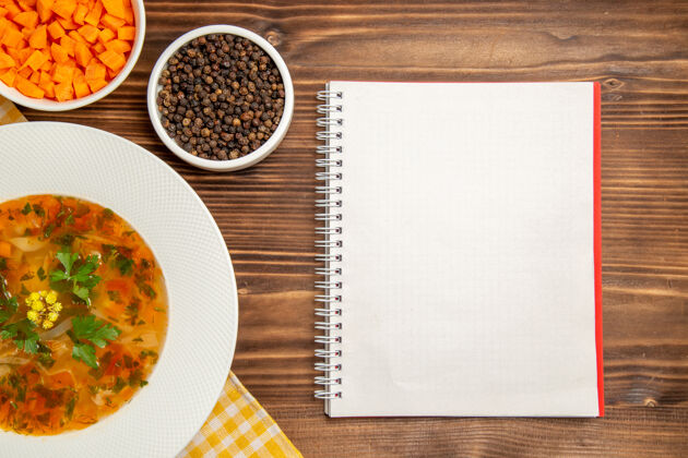 蔬菜俯瞰美味的蔬菜汤与调味品在棕色的木制桌子上汤食品蔬菜调味品一餐笔记本桌子饭
