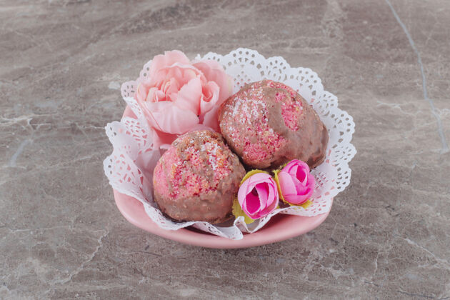 美味小蛋糕和花冠放在一个铺着桌布的碗里 放在大理石上糖口感糕点
