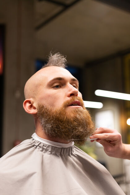 客户在理发店剪胡子的欧洲野蛮人机器帅哥剪
