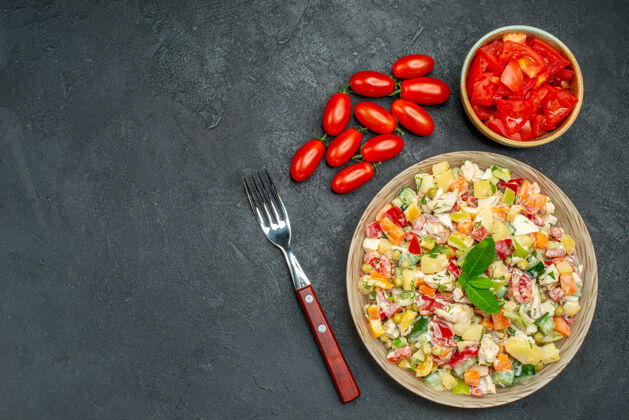 肉深灰色背景上番茄和叉子蔬菜沙拉的俯视图辣椒午餐蔬菜