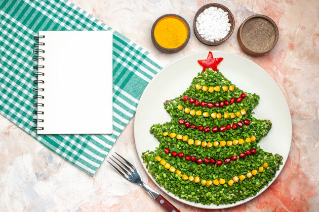 饭顶视图美味的绿色沙拉在新年树形状与调味品在轻背景树冷杉光