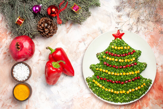 礼物顶视图美味的绿色沙拉在新年树形状与调味品在轻背景礼物树饭