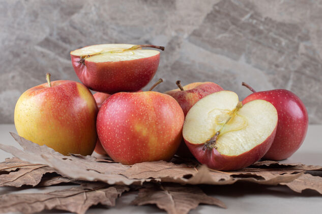 苹果在大理石上的一捆切好的苹果下 梧桐树的叶子营养新鲜捆绑