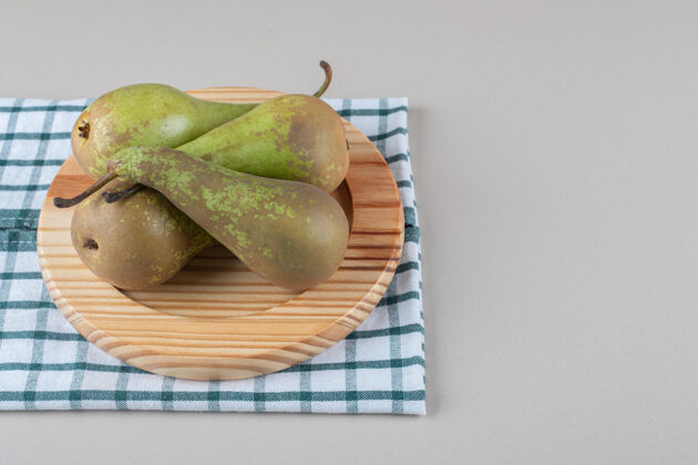 饮食美味的梨捆在毛巾上的木盘上 大理石上天然健康有机