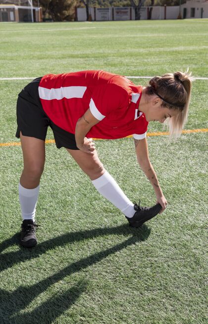 练习足球场上的全速女子伸展活跃足球场健身