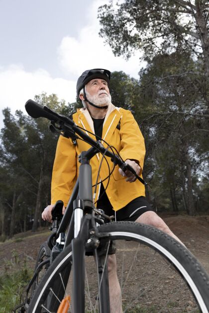 活动山上骑自行车的老人画像男性山自然