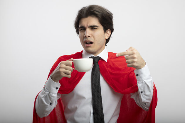 家伙印象深刻的年轻超级英雄家伙戴领带举行和点在咖啡杯上孤立的白色背景印象点咖啡
