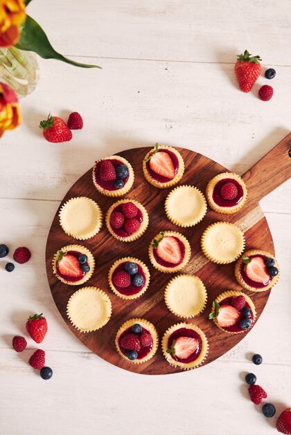 味道高角度拍摄的奶酪蛋糕与水果果冻和水果在一个木制的盘子早餐蓝莓板