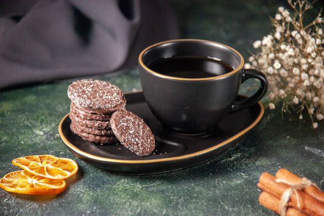 前面前视一杯红茶 茶杯和盘子上放着饼干 表面颜色为深色的糖浆 仪式上有一杯早餐甜点蛋糕盘子仪式杯子