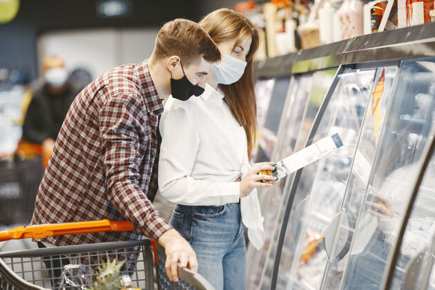 口罩一对夫妇戴着医用防护面具在超市里女孩预防购买