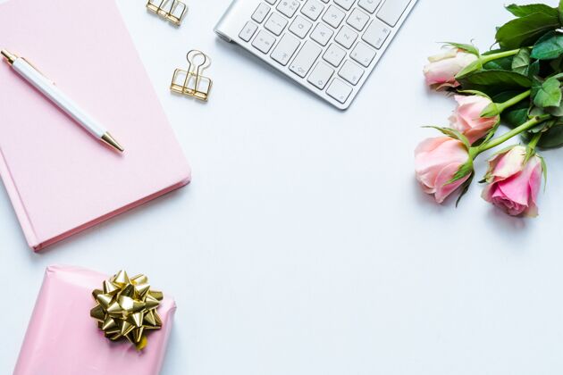 浪漫粉色笔记本 一支笔 一个礼品盒 一个键盘和白色背景上的粉色玫瑰明亮键盘礼品盒