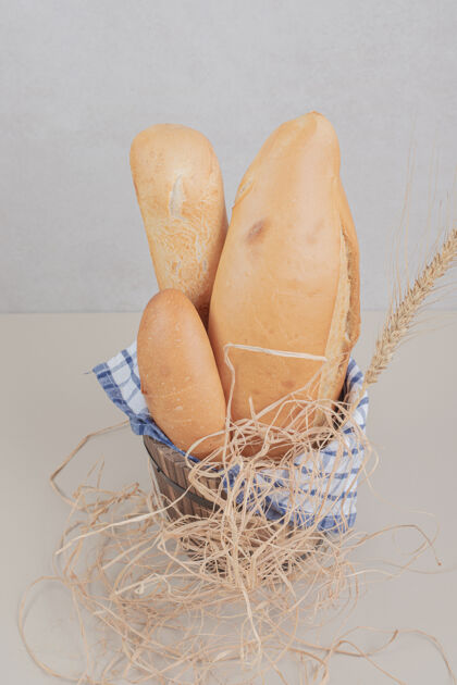 面包用桌布把新鲜的面包糕点放在木篮里面包房食品美味