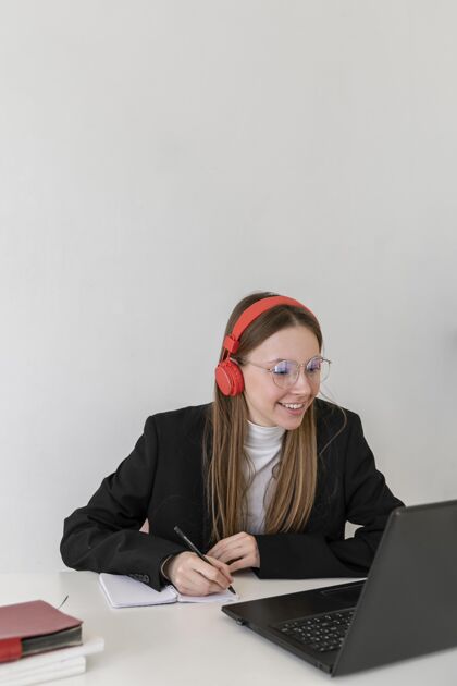 工人中等身材的女人用笔记本电脑工作耳机设备专业