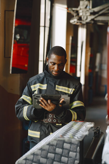 设备穿制服的消防队员准备工作的人拿着平板电脑的人非洲超级英雄中间