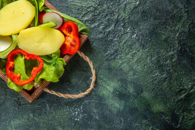 切碎的蔬菜半拍新鲜切碎的蔬菜放在木质托盘上 在混合颜色的表面上 有自由空间正餐西红柿木头