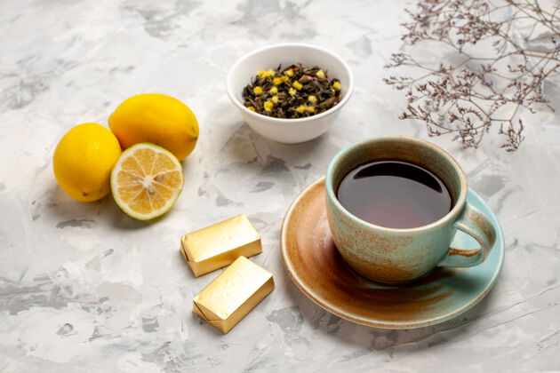 早餐前视图一杯茶 白色空间上有糖果和柠檬咖啡前面早晨
