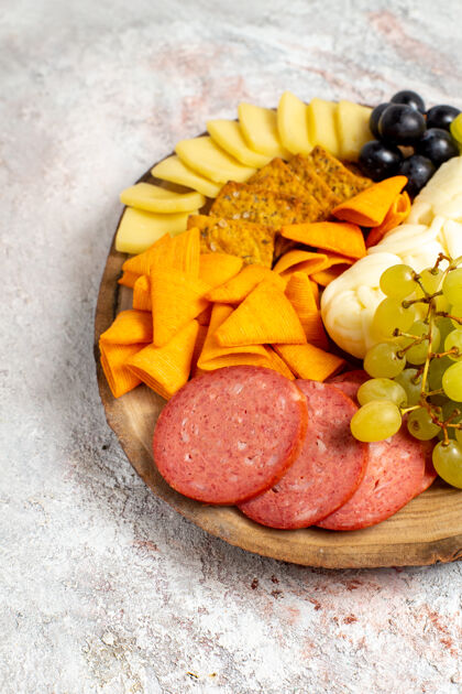香肠前视图不同的小吃cips香肠奶酪和新鲜葡萄上的白色空间桃健康可食用的水果
