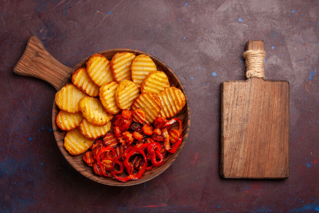 玉米顶视图烤土豆与熟蔬菜内板上的黑暗空间顶部烘焙里面