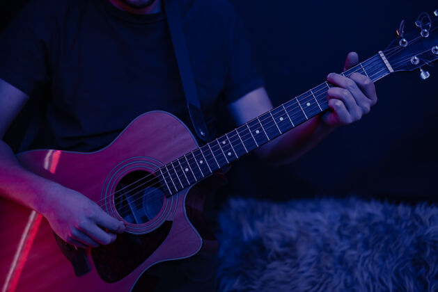 声学一个男人在黑暗的房间里弹原声吉他现场表演 原声音乐会吉他和弦男人