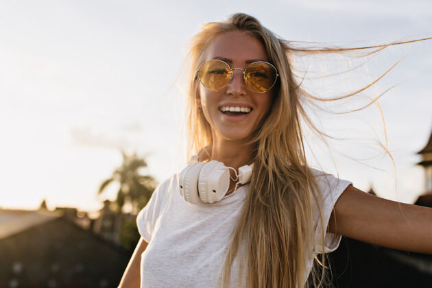 阳光浪漫的女孩 戴着大耳机 在美好的夏日里表达真正积极的情感城市微笑阳光