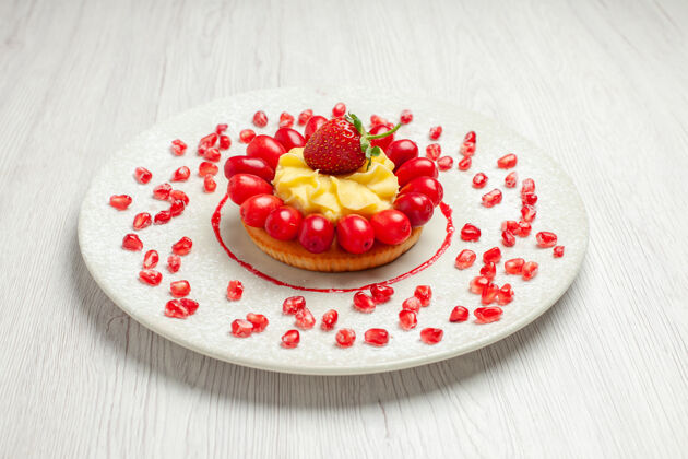 水果前视图美味的奶油蛋糕与山茱萸在白色办公桌水果蛋糕甜点农产品桌子蛋糕