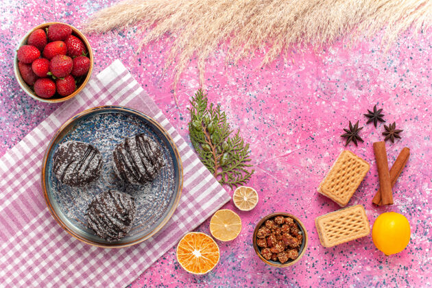 桌子顶视图美味的巧克力蛋糕与新鲜的红色草莓粉红水果杯子美味