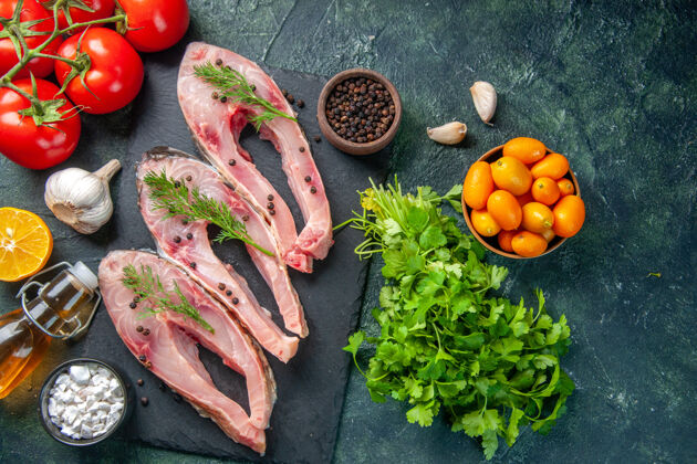 红色顶视图新鲜鱼片与红色西红柿和绿色的深色背景晚餐风景蔬菜