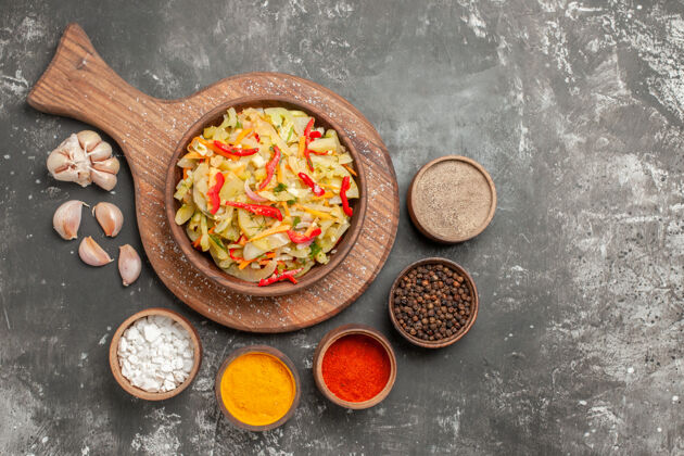 勺子顶部特写镜头沙拉大蒜碗五颜六色的香料蔬菜沙拉在砧板上香料伙食大蒜
