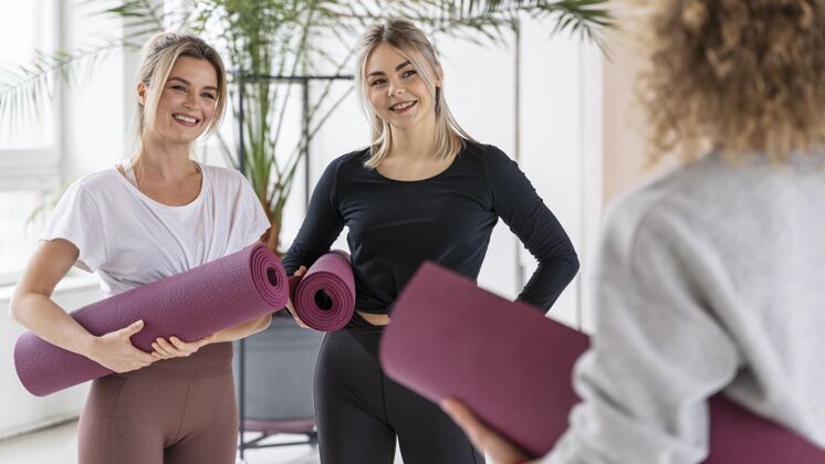 运动用瑜伽垫特写笑脸女人瑜伽老师工作室内