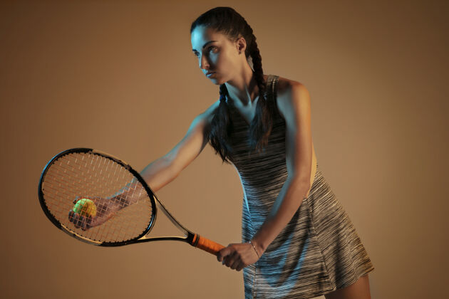 轮廓在棕色墙上打网球的女人抱着混合活动