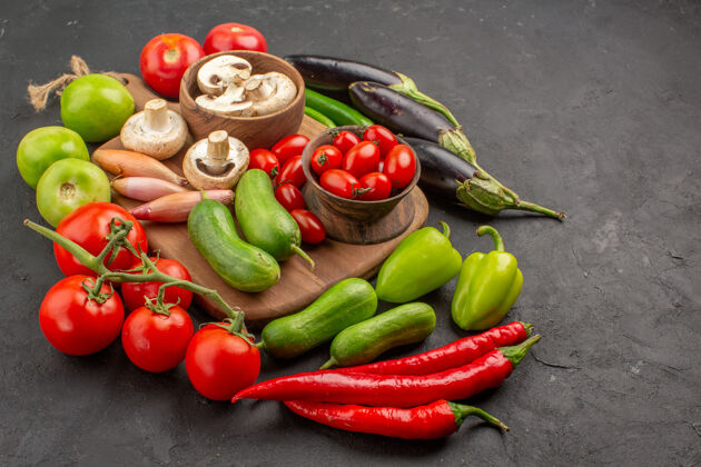 甜椒前视新鲜蔬菜组成深色餐桌上的新鲜色拉熟了蔬菜黑辣椒