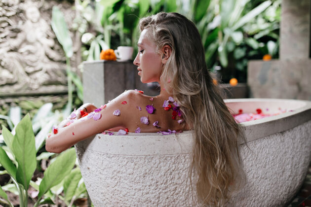 休闲快乐的长发女人在浴缸里放松美丽的女士在周末用玫瑰做spa梦幻人类治疗