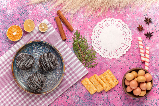 糖果顶视图美味的巧克力蛋糕糖果和薯片上的粉红色鸡蛋肉桂饼干