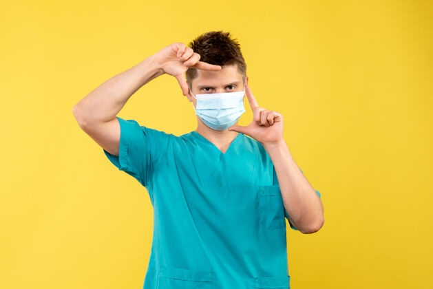 疾病黄墙上的男医生穿着医疗服 戴着无菌口罩医疗绝育运动装