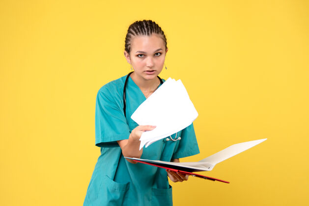 人黄色墙壁上穿着不同分析的医疗服的女医生的正面图医疗工作不同