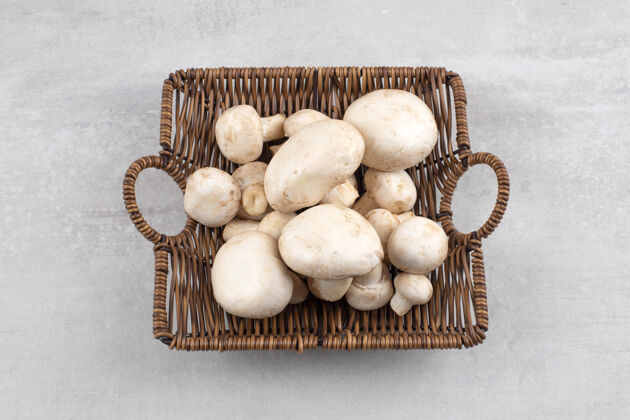 篮子蘑菇放在柳条篮子里 放在大理石桌上配料蘑菇营养