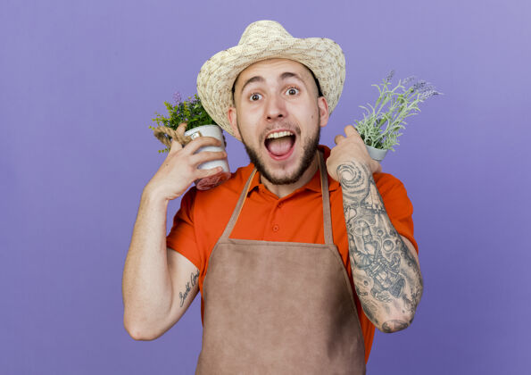 帽子惊讶的男园丁戴着园艺帽 肩上扛着花盆复制紫色惊喜
