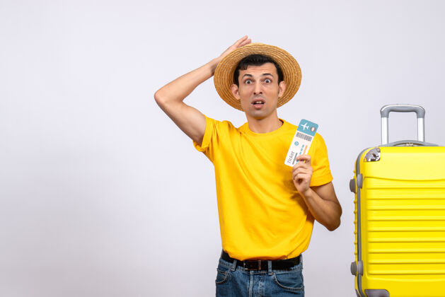 手提箱正面图：一个穿着黄色t恤的年轻人站在手提箱旁举着票向上人黄色