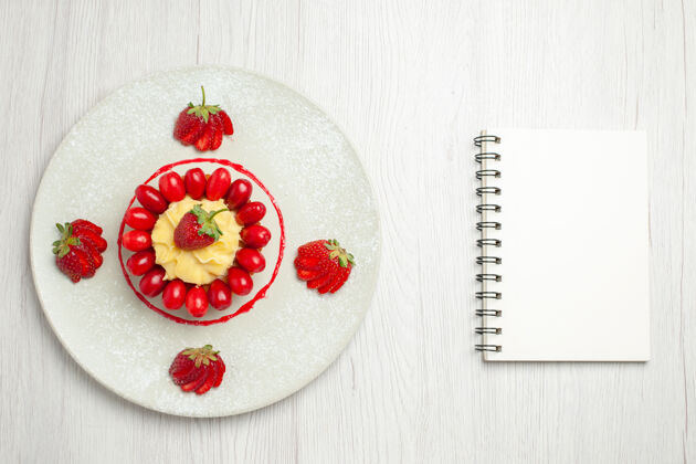 蛋糕俯瞰美味的小蛋糕与水果在盘子里的白色办公桌上食物水果冬天
