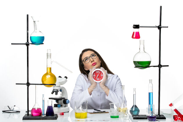 科学前视图穿着白色医疗服的女化学家拿着白色背景上的时钟科学病毒实验室病毒-大流行液体实验室视图